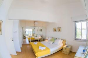 Un dormitorio con una cama grande con una manta amarilla. en Coral Bay Beach House Apartment, en Peyia