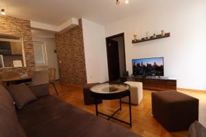 a living room with a couch and a table at Lux Apartment Rose 2 60m2 in Kragujevac