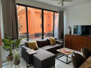 a living room with a couch and a large window at NEW Luxury Condo - In the heart of Santa Maria in Santa Maria