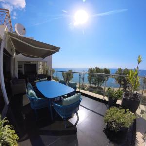 a balcony with a blue table and chairs and the ocean at The View Beach Penthouse in Limassol +15 photos