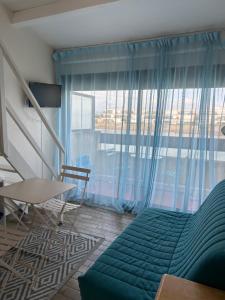 una habitación con una cama y una mesa y una ventana en studio village naturiste, en Leucate