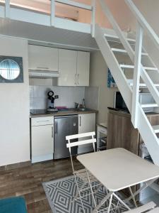 una cocina con gabinetes blancos y una escalera en una habitación en studio village naturiste, en Leucate