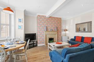 イーストボーンにあるBay Tree Apartmentの青いソファと暖炉のあるリビングルーム