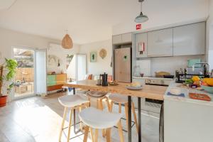 a kitchen with a table and stools in it at La Concha Alegre, Duplex in Trafaria in Trafaria