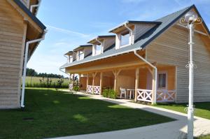 a house with a porch and a lawn at Lawendowa Wyspa Klub Nadmorski in Ostrowo