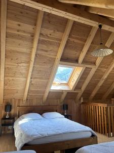 a bedroom with a large bed in a wooden ceiling at Chalet Moulinot in Valloire