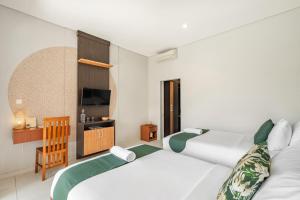 a hotel room with two beds and a television at Cove Arganta in Dalung +37 photos