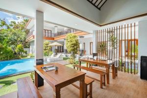 an open living room with tables and a swimming pool at Cove Arganta in Dalung