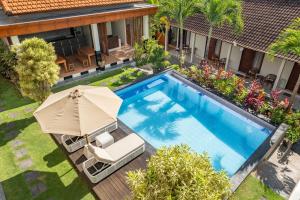 an overhead view of a swimming pool with an umbrella and a chair and an umbrella at Cove Arganta in Dalung