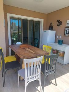 a dining room with a wooden table and chairs at Flecheiras in Trairi