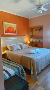 two beds in a room with orange walls at Hotel del Rio - La Cruz Corrientes in La Cruz +81 photos