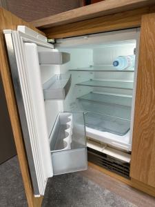 an empty refrigerator with its door open at City Oasis with private parking in The Hague