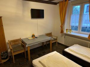a room with a table and chairs and a tv at Pension Hoffmann in Wuppertal