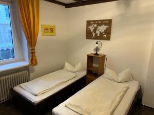 two twin beds in a room with a window at Pension Hoffmann in Wuppertal