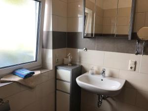a small bathroom with a sink and a window at Fewo Stremme in Altenlotheim