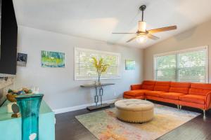 ein Wohnzimmer mit einem orangenen Sofa und einem Deckenventilator in der Unterkunft Spacious 3-BR Home with Patio, Firepit & BBQ! in Largo