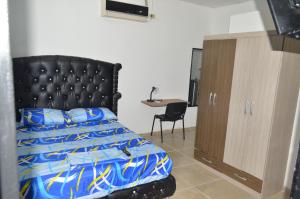 a bedroom with a bed with a black headboard and a desk at Apartaestudio buenos aires in Barrancabermeja
