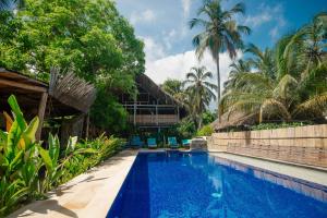 a resort swimming pool with palm trees in the background at Finca Escondida in Palomino