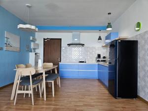 a kitchen with blue cabinets and a table with chairs at House Of 99 in Kuantan
