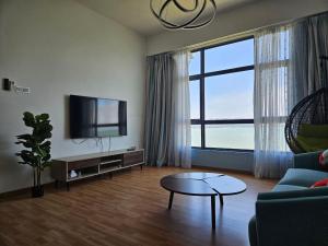 a living room with a couch and a tv and a table at House Of 99 in Kuantan