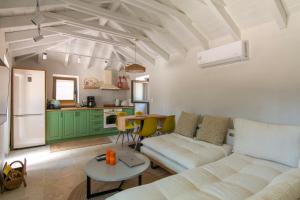 a living room with a white couch and a kitchen at olive grove by the sea 30m from the beach in Kardamili