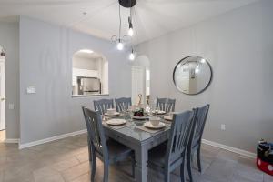 a dining room with a table and chairs and a mirror at 7671 Comrow Unit 205 in Kissimmee