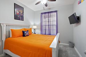 a bedroom with an orange bed and a tv at 7671 Comrow Unit 205 in Kissimmee