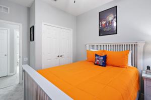 a bedroom with a bed with an orange bedspread at 7671 Comrow Unit 205 in Kissimmee