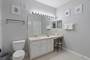 a bathroom with a toilet and a sink and a mirror at 7671 Comrow Unit 205 in Kissimmee