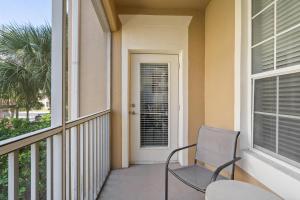 a balcony with a chair and a door at 7671 Comrow Unit 205 in Kissimmee
