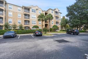 a parking lot with cars parked in front of a building at 7671 Comrow Unit 205 in Kissimmee