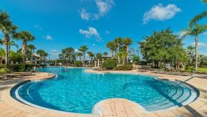 a swimming pool at a resort with palm trees at 7671 Comrow Unit 205 in Kissimmee