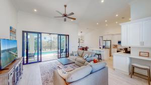a large living room with a couch and a kitchen at Inland home with pool and walk to Park/Museum/Library in Marco Island