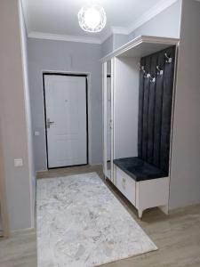 una stanza con un armadio con una panca nera e una porta di Lux apartments in Turkistan a Türkistan
