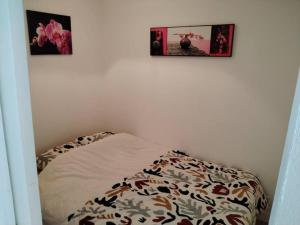 a bed in a room with two pictures on the wall at Appartement vue mer 4 personnes in Les Bains