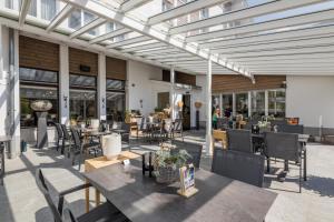 an outdoor patio with tables and chairs and windows at Hotel Rischli in Sörenberg
