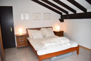 a bedroom with a bed with white sheets and two night stands at La Schmetta 38 in Lenzerheide