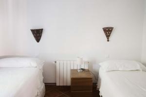 una camera da letto con due letti e una lampada sul comodino di CASA BUGANVILLA a Barbate Altre 21 foto