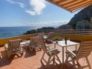 a patio with a table and chairs and the ocean at 29D Vistas espectaculares parking and wifi in Calpe