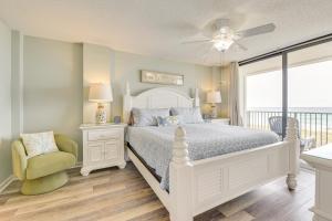 een witte slaapkamer met een bed en een stoel bij Oceanfront Condo with Heated Pool in Emerald Surf! in Navarre +24 foto's