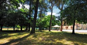 a park with trees and a tent in the distance at Villa Raffaello Park Hotel in Assisi