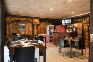a restaurant with tables and chairs in a room at Biggy Best Boutique Hotel & Self Catering Cottages in Howick