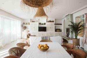 una stanza con un tavolo con una ciotola di frutta sopra di CASA BUGANVILLA a Barbate