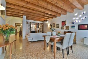 un salon avec une table et des chaises de salle à manger dans l'établissement PadovaResidence Apartments - vista Piazza delle Erbe e Palazzo della Ragione, à Padoue
