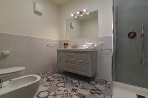 La salle de bains est pourvue d'un lavabo, de toilettes et d'une douche. dans l'établissement PadovaResidence Apartments - vista Piazza delle Erbe e Palazzo della Ragione, à Padoue 27 autres photos
