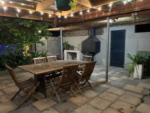 a wooden table and chairs on a patio at Tehillah on Boom in Bothasig