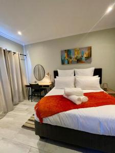 a bedroom with a large bed with a red blanket at Tehillah on Boom in Bothasig +32 photos