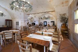 a dining room with wooden tables and chairs at Masseria Borgo Santuri in Ostuni