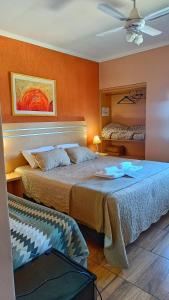 two beds in a room with orange walls at Hotel del Rio - La Cruz Corrientes in La Cruz