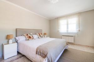 Un dormitorio con una gran cama blanca y una ventana. en El Jardín de Estrella, en Navacerrada 65 fotos más